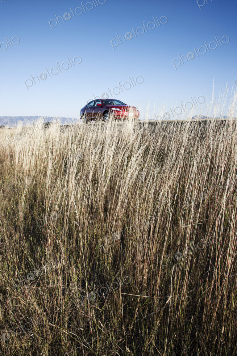 A red sedan parked along a highway in eastern Washington State, USA.