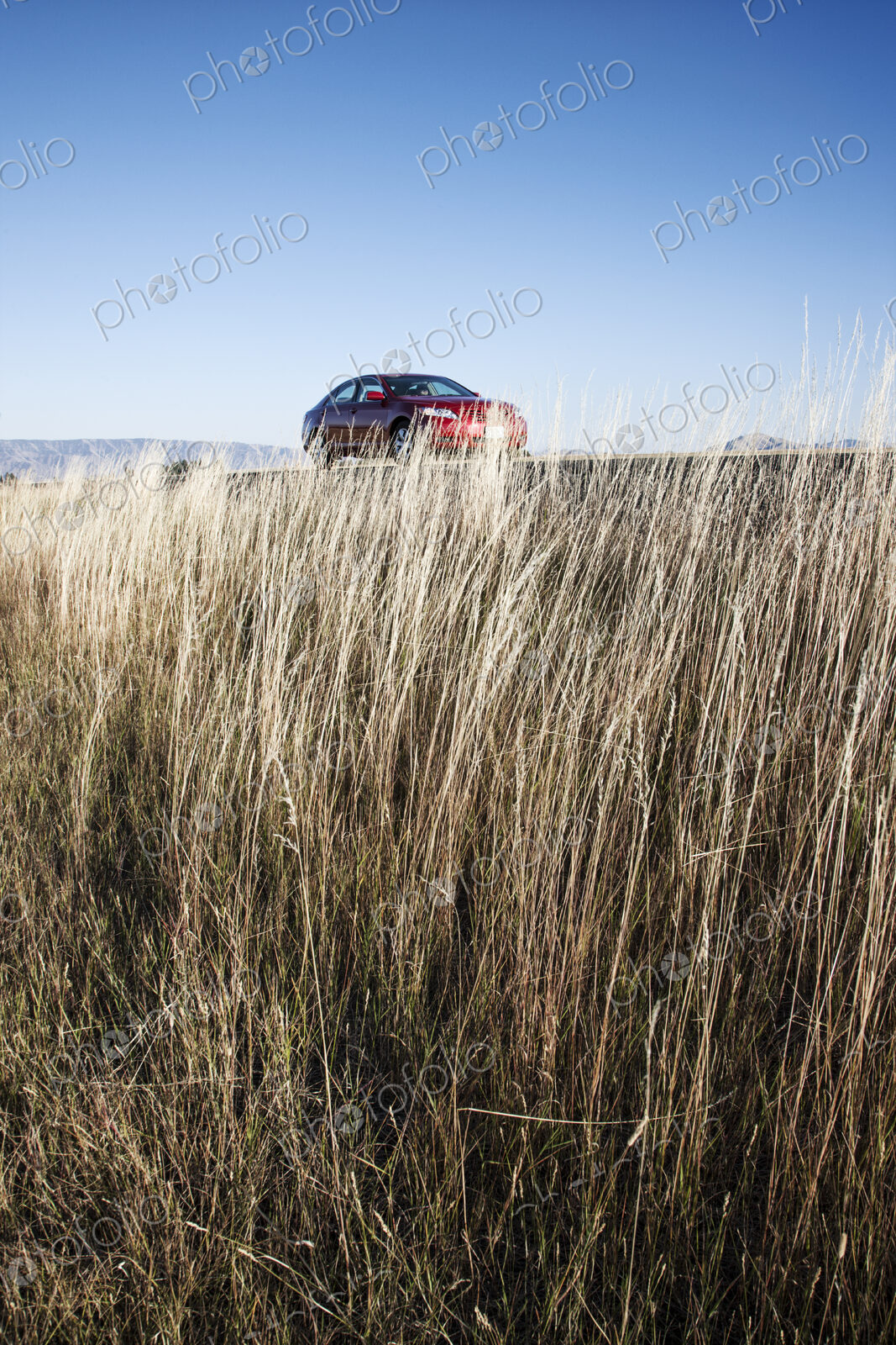 A red sedan parked along a highway in eastern Washington State, USA.