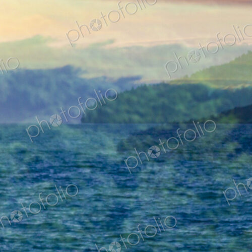 A reflection in window glass of the forest, mountains and moving water. A reflection in window glass of the forest, mountains and moving water.