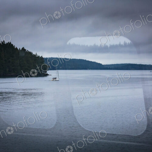 A reflection on a ferry window and view of the San Juan Islands ferry A reflection on a ferry window and view of the San Juan Islands ferry