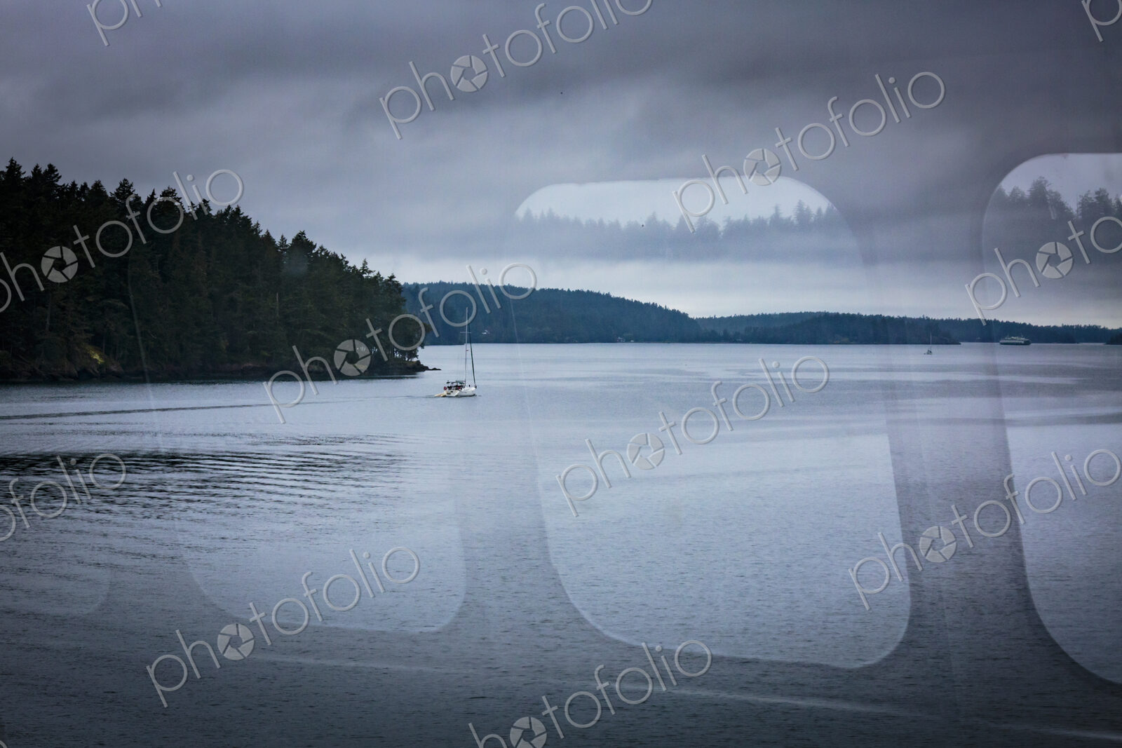 A reflection on a ferry window and view of the San Juan Islands ferry