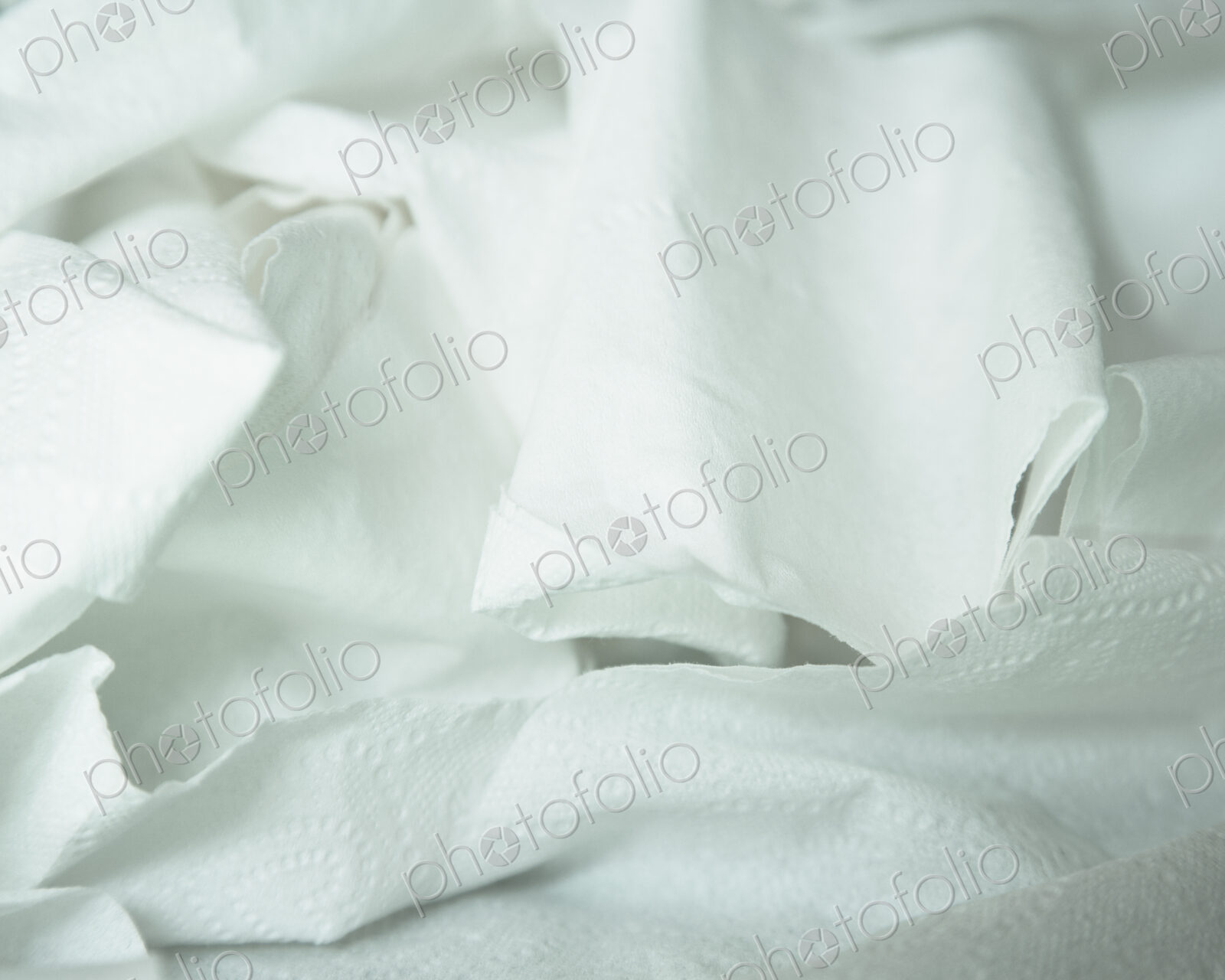 A roll of toilet paper, unwound and crumpled.