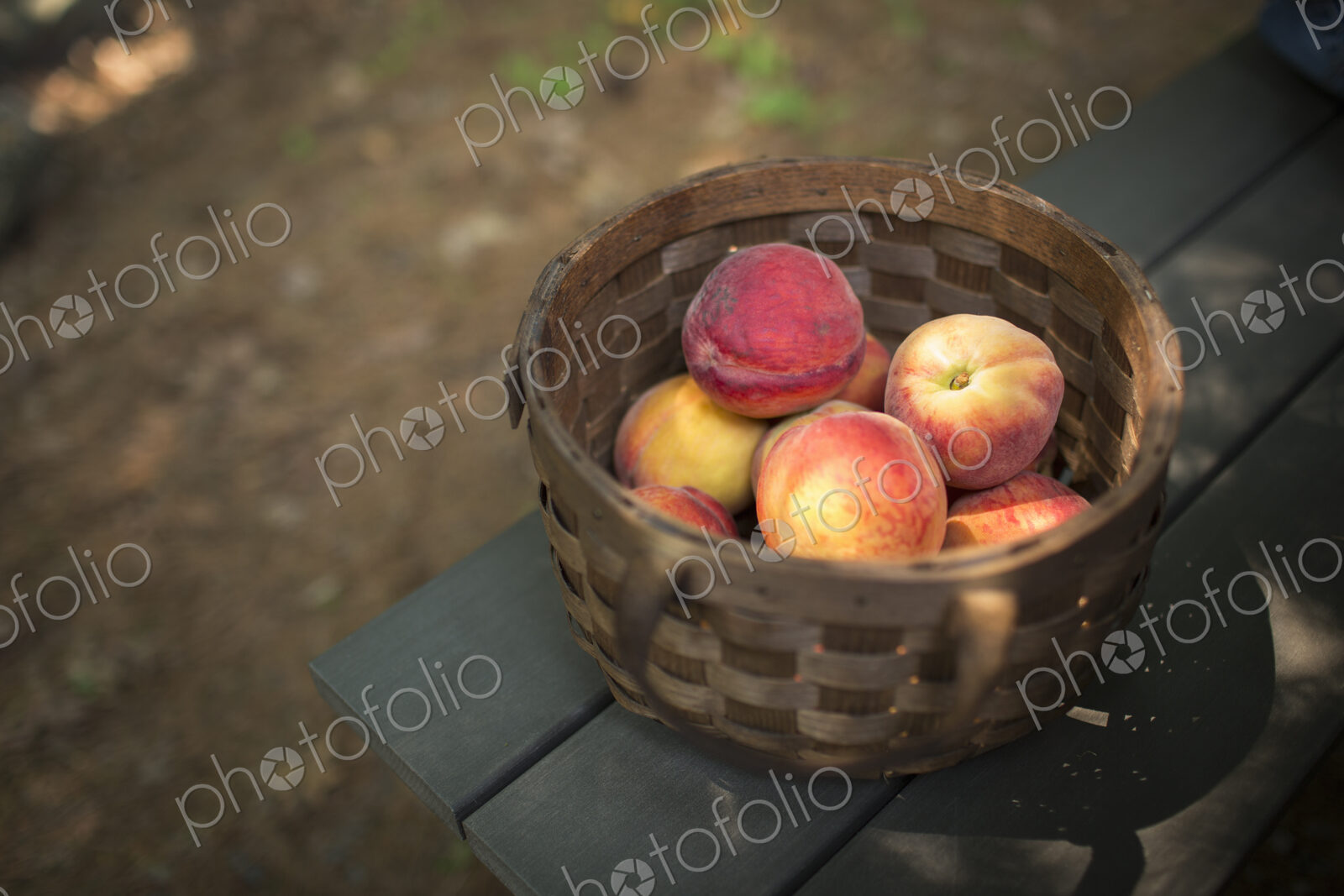 A round basket of fresh peaches, fruits.