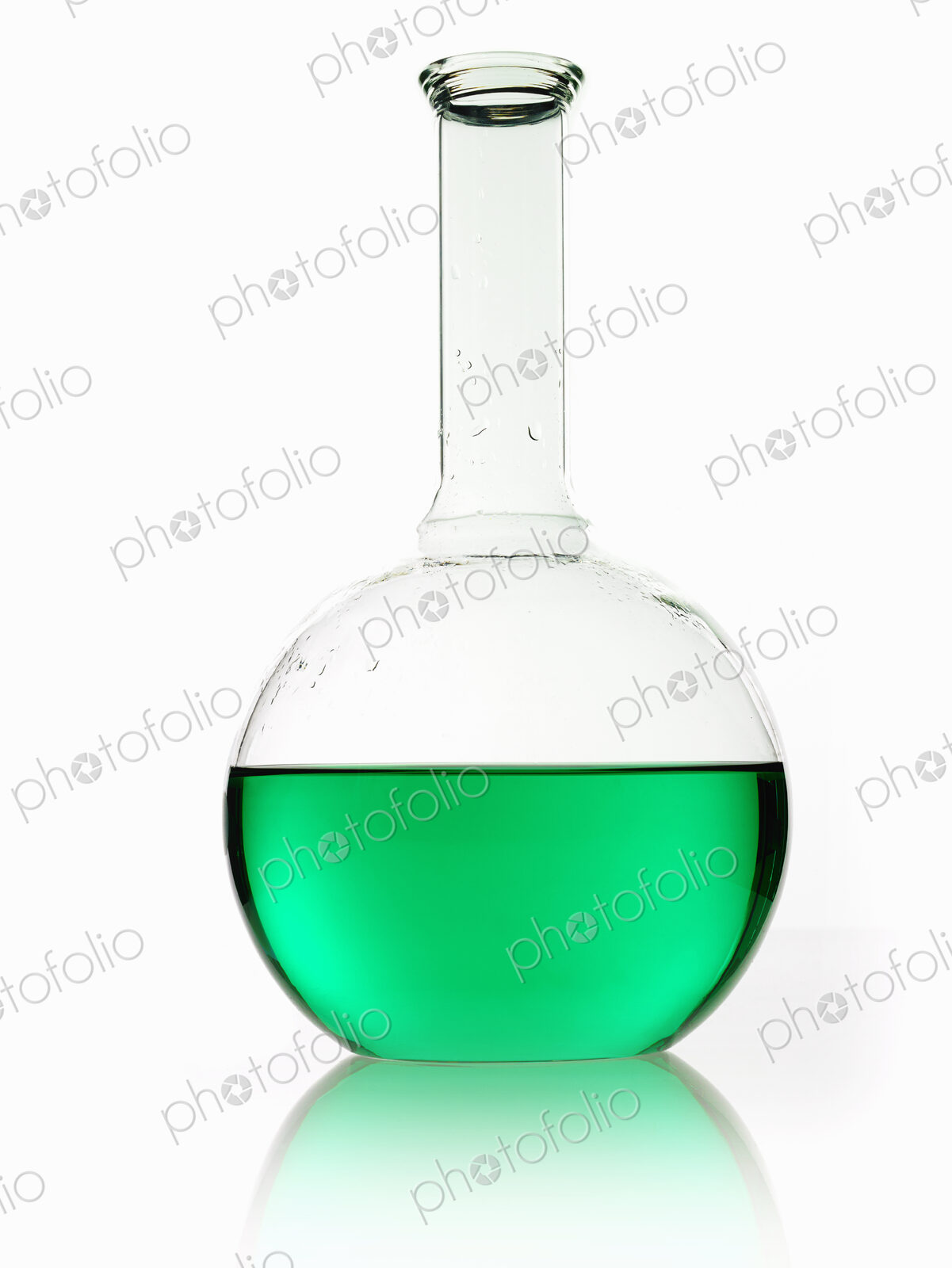 A rounded glass scientific chemical flask with a long funnel neck, holding green liquid.