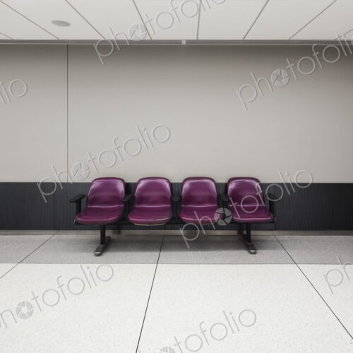 A row of four fixed seats in an empty airport