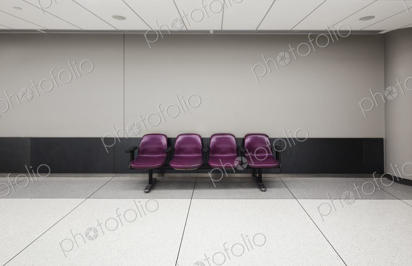 A row of four fixed seats in an empty airport