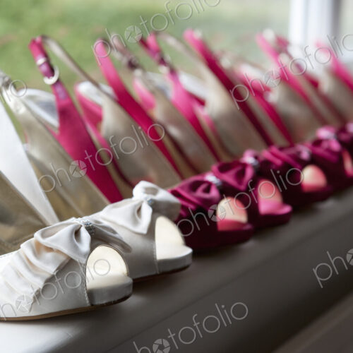 A row of high heeled shoes. Pairs of peep toe slingbacks in white and pink. Special…