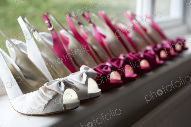 A row of high heeled shoes. Pairs of peep toe slingbacks in white and pink. Special…
