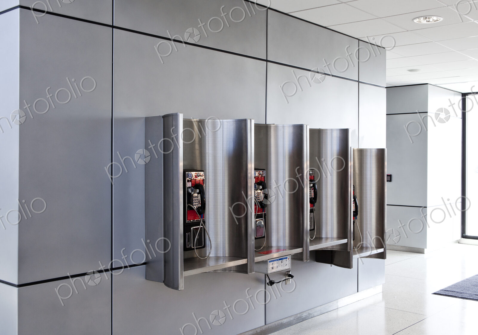 A row of public telephones in booths at an airport.