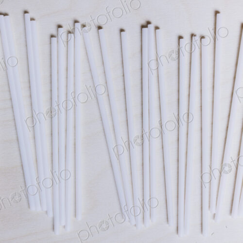 A row of white plastic drinking straws. A row of white plastic drinking straws.