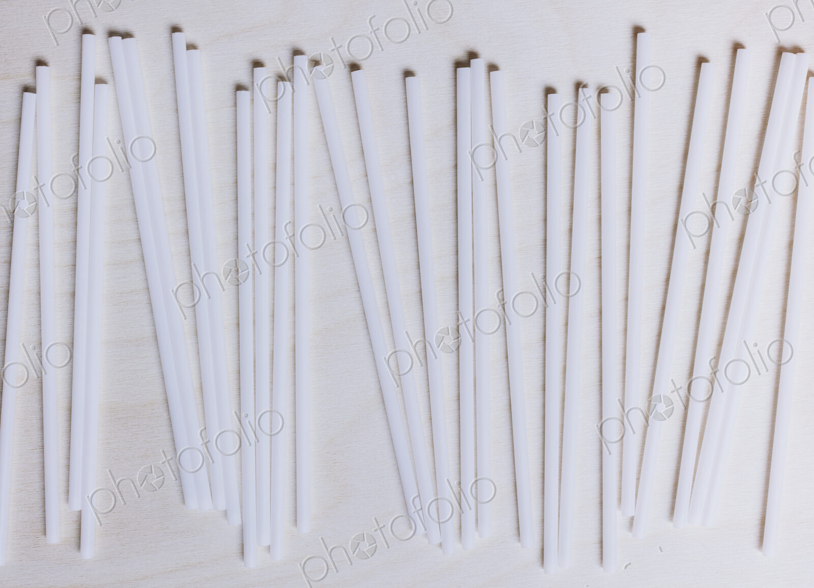 A row of white plastic drinking straws.