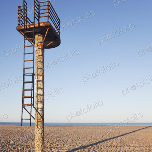 A rusting lifeguard tower on an empty beach early in the morning near Almeria
