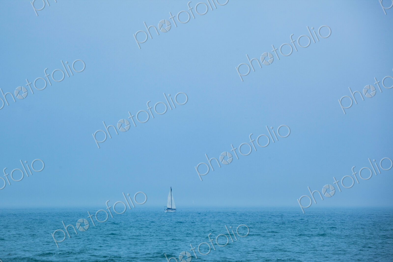 A sailboat on the ocean, view over water.