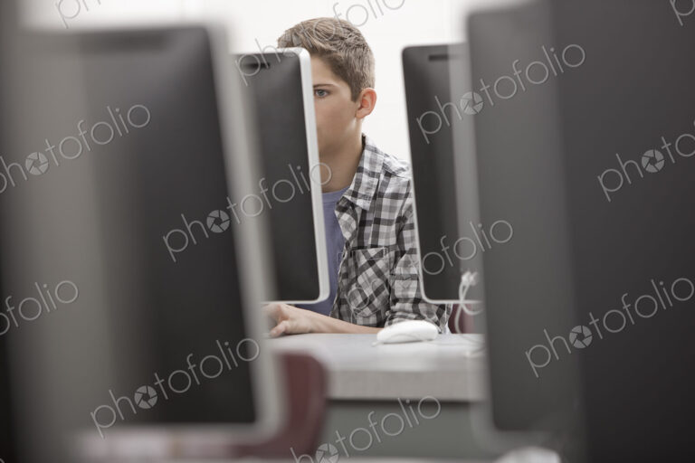 A school room, computer laboratory or lab with rows of computer monitors and seating.…