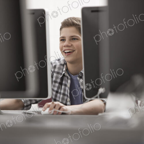 A school room, computer laboratory or lab with rows of computer monitors and seating.…