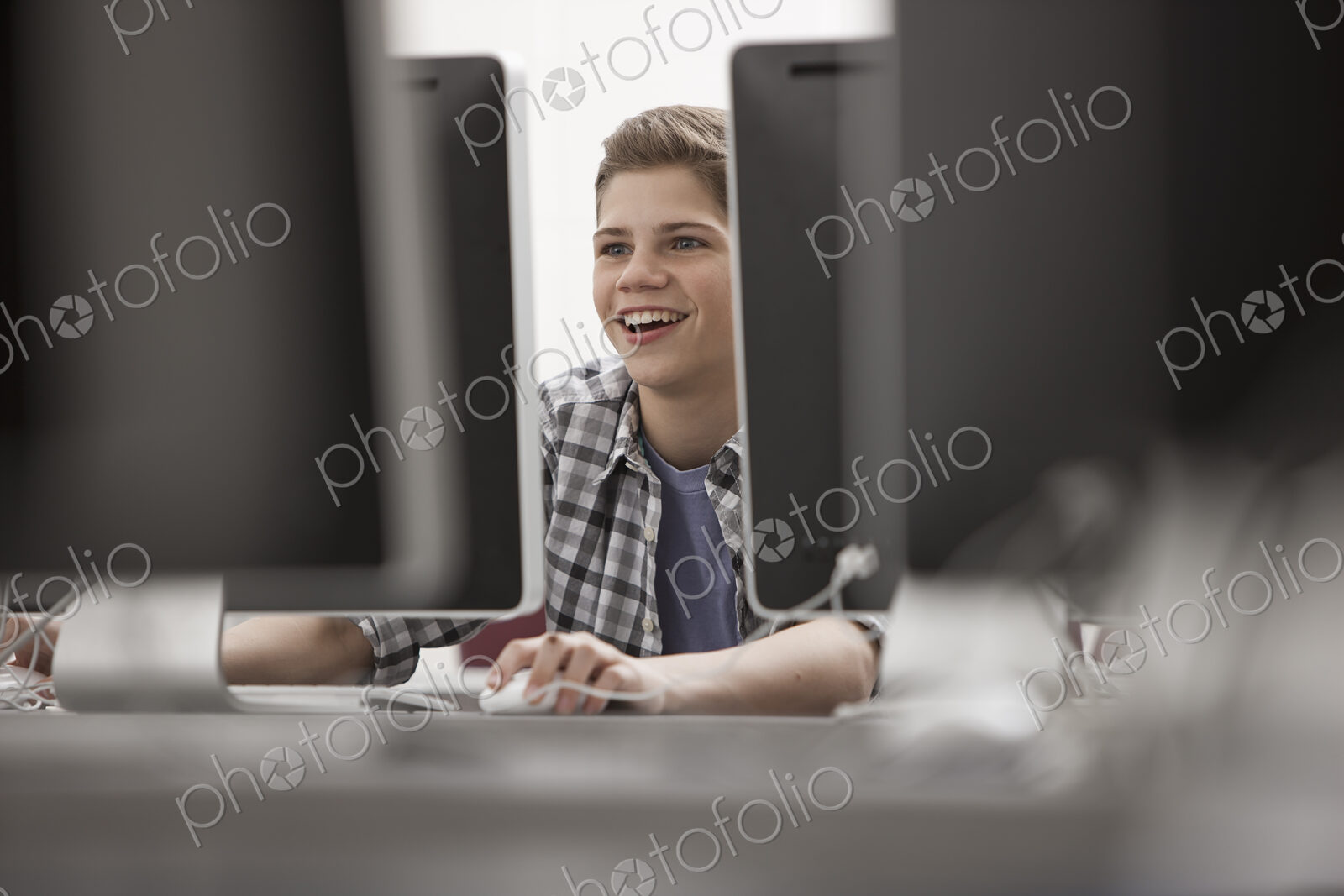 A school room, computer laboratory or lab with rows of computer monitors and seating.…