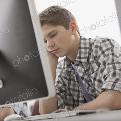 A school room, computer laboratory or lab with rows of computer monitors and seating.…