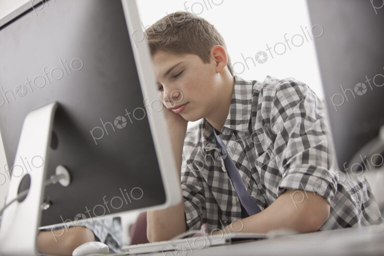 A school room, computer laboratory or lab with rows of computer monitors and seating.…