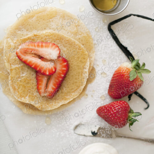 A selection of party desserts. Pancakes, freshly cooked, with strawberries and a… A selection of party desserts. Pancakes, freshly cooked, with strawberries and a…
