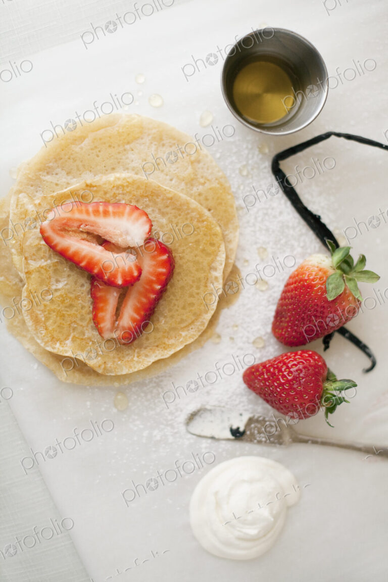 A selection of party desserts. Pancakes, freshly cooked, with strawberries and a…