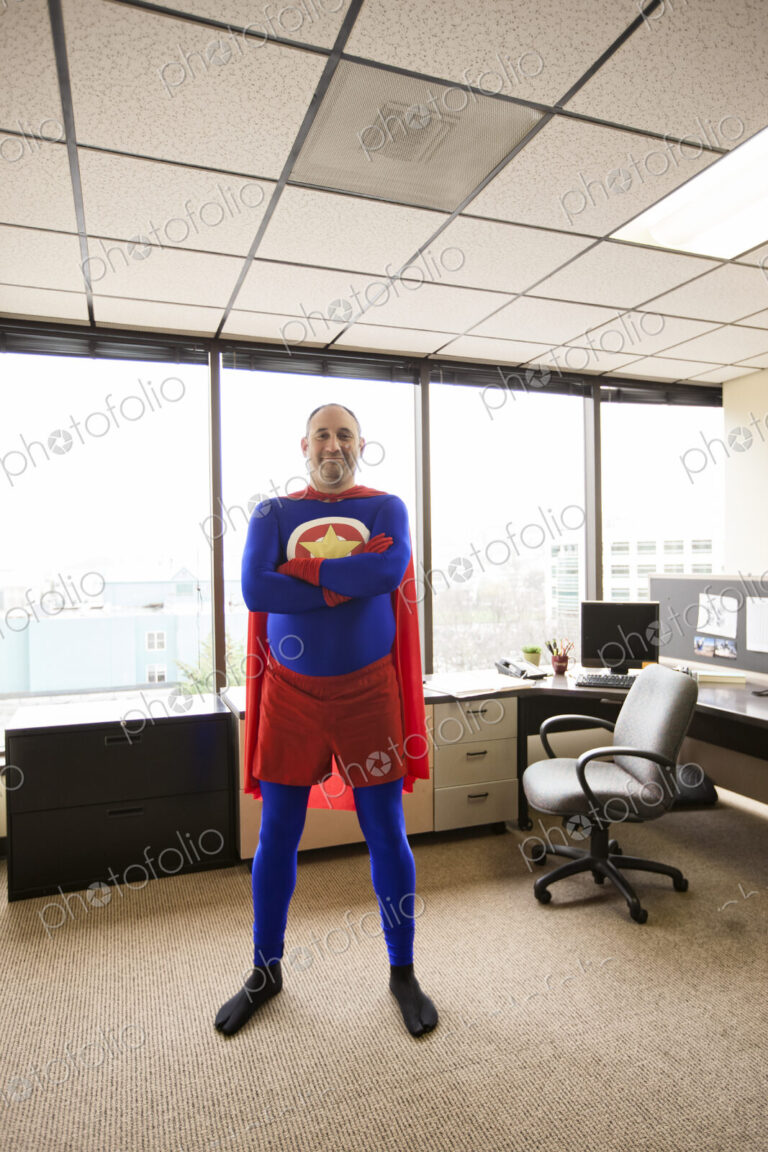 A self satisfied caucasian office super hero in his cubicle office.