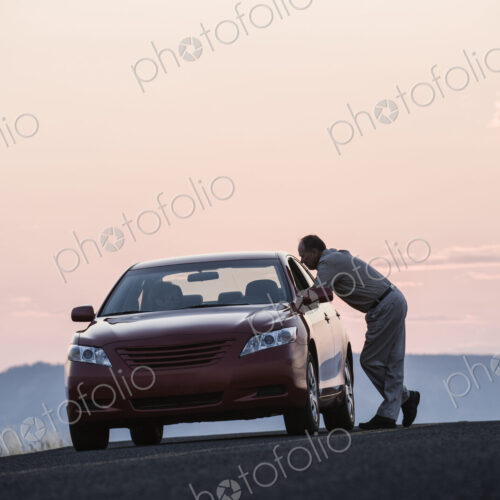 A senior Caucasian man leaning in a car window chatting with a person in the… A senior Caucasian man leaning in a car window chatting with a person in the…