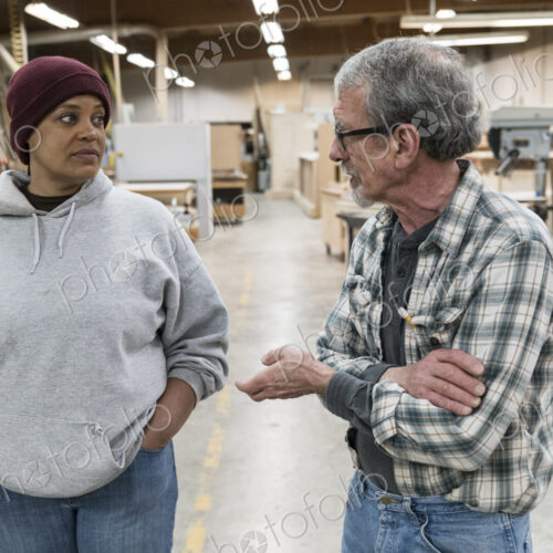 A senior causian male carpenter and a Black female carpenter discussion a project in a… A senior causian male carpenter and a Black female carpenter discussion a project in a…