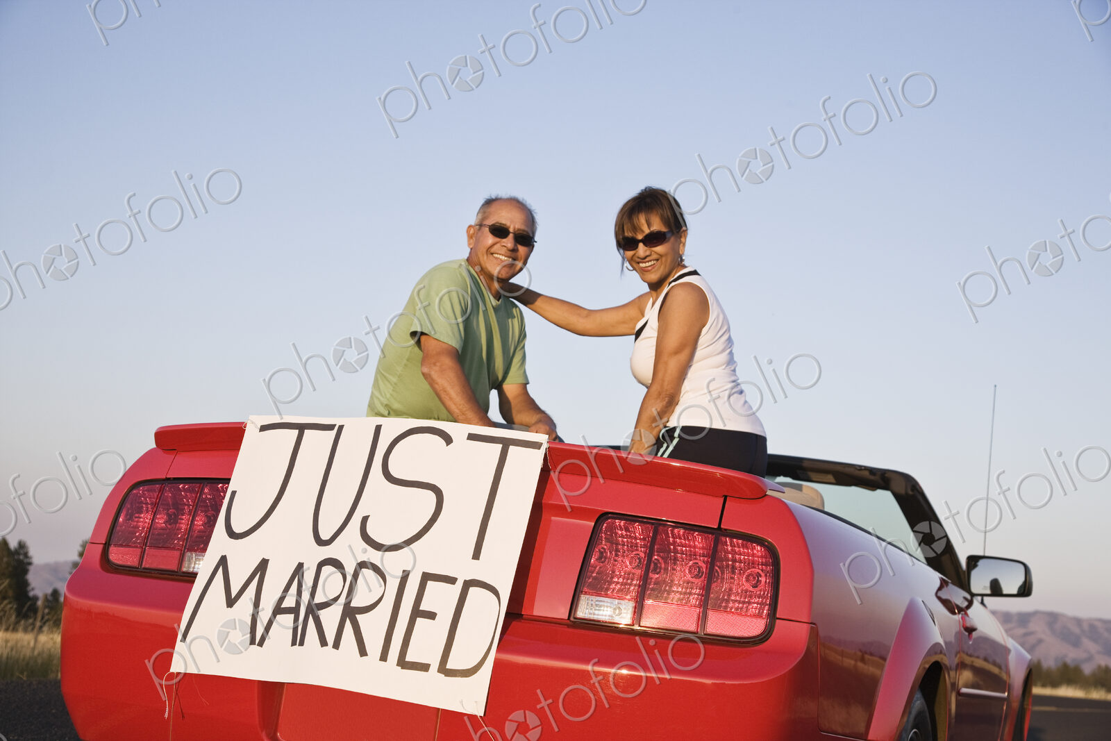 A senior couple “just married” sitting in a convertible sports car in eastern…