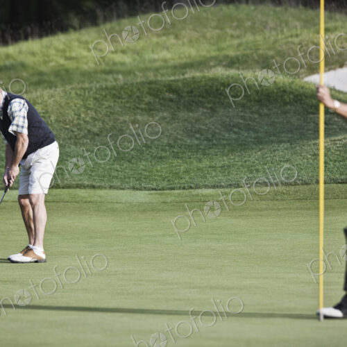 A senior golfer about to attempt a putt on a golf course. A senior golfer about to attempt a putt on a golf course.