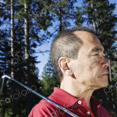 A senior golfer ready to approach the next shot on a golf course. A senior golfer ready to approach the next shot on a golf course.