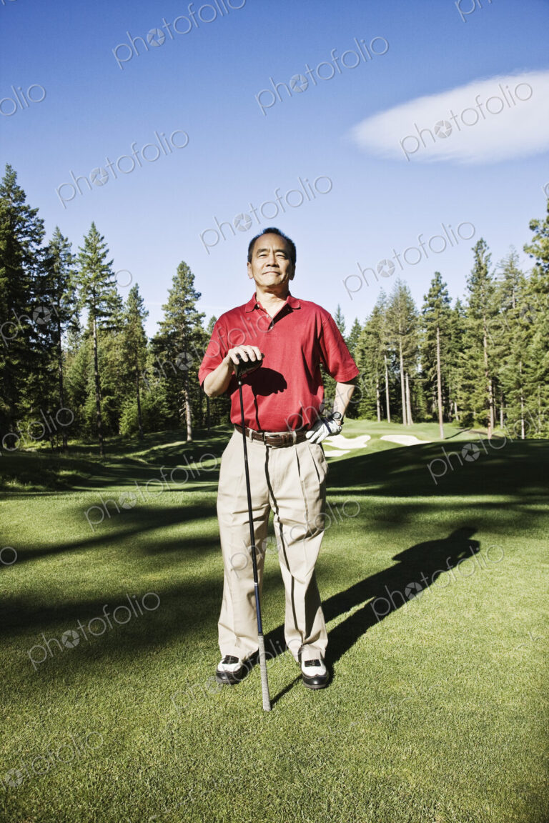 A senior golfer ready to approach the next shot on a golf course.