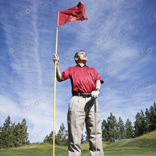 A senior golfer ready to approach the next shot on a golf course. A senior golfer ready to approach the next shot on a golf course.