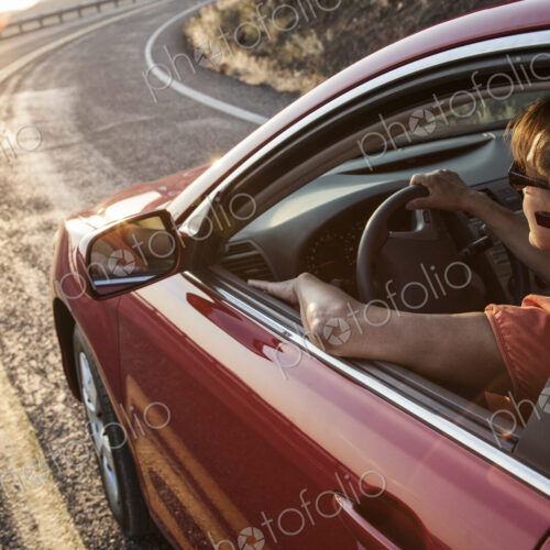 A senior woman at the wheel of her car with an ear piece for communications. A senior woman at the wheel of her car with an ear piece for communications.