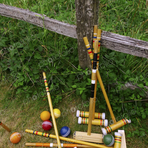 A set of croquet mallets and coloured balls.