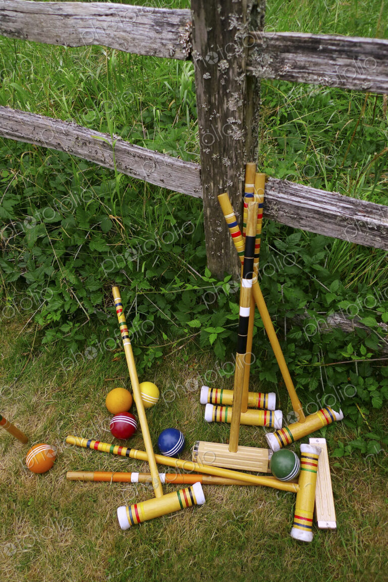 A set of croquet mallets and coloured balls.