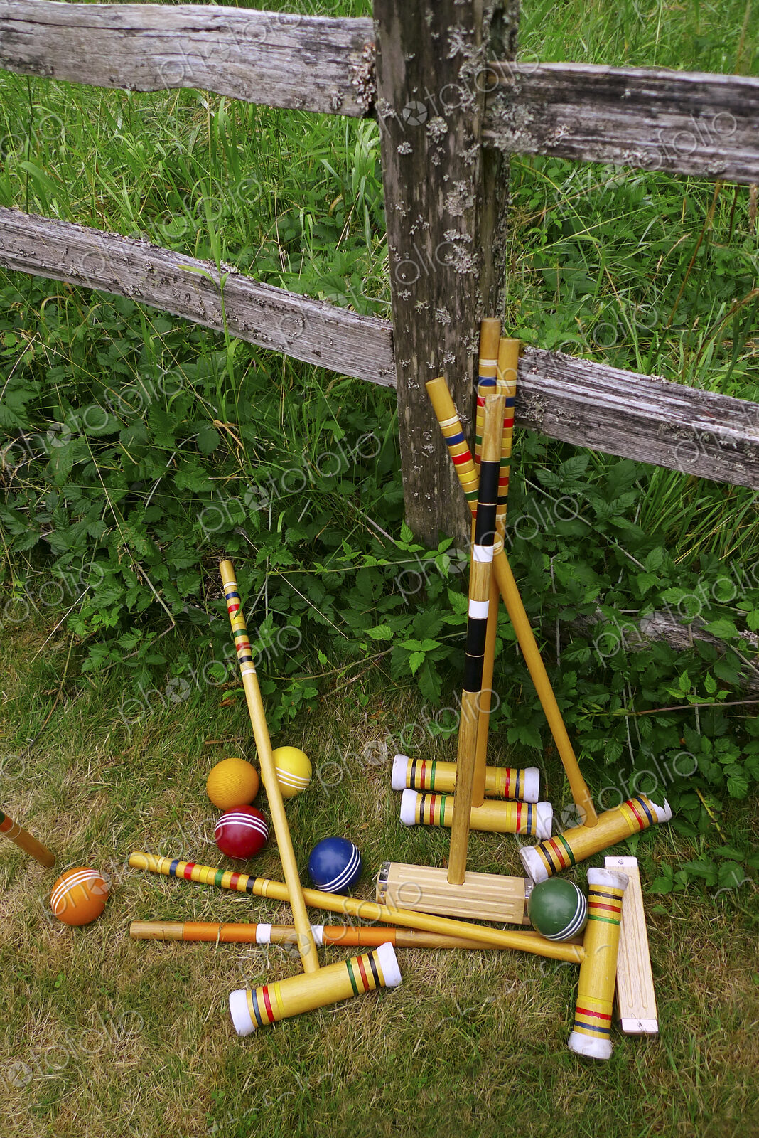 A set of croquet mallets and coloured balls.