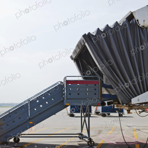 A set of steps and a mobile airport departure passenger tunnel, air bridge A set of steps and a mobile airport departure passenger tunnel, air bridge