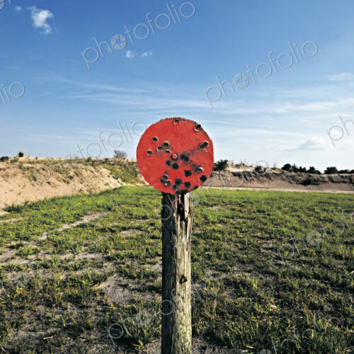 A shooting range target with bullet holes.