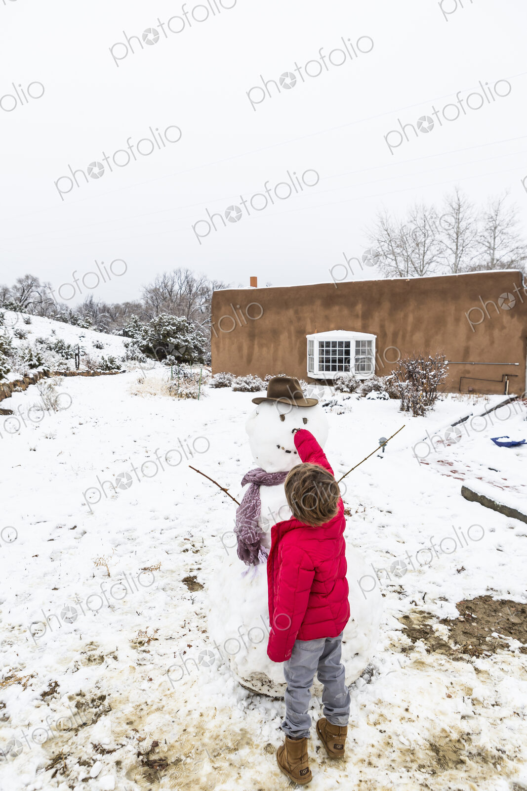 A six year old boy building a snowman