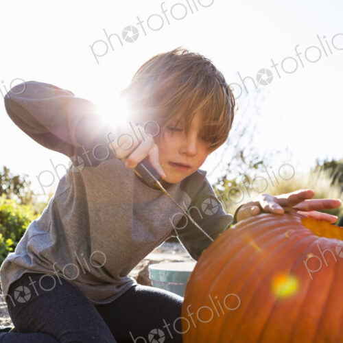 A six year old boy carving a pumpkin at Halloween. A six year old boy carving a pumpkin at Halloween.