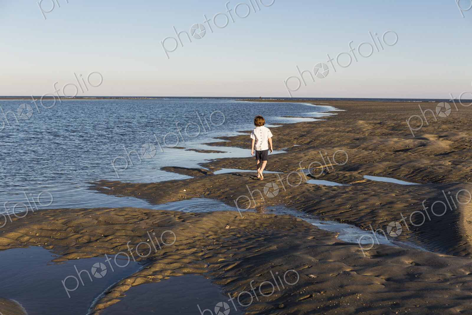 A six year old boy investigating sandy landscape