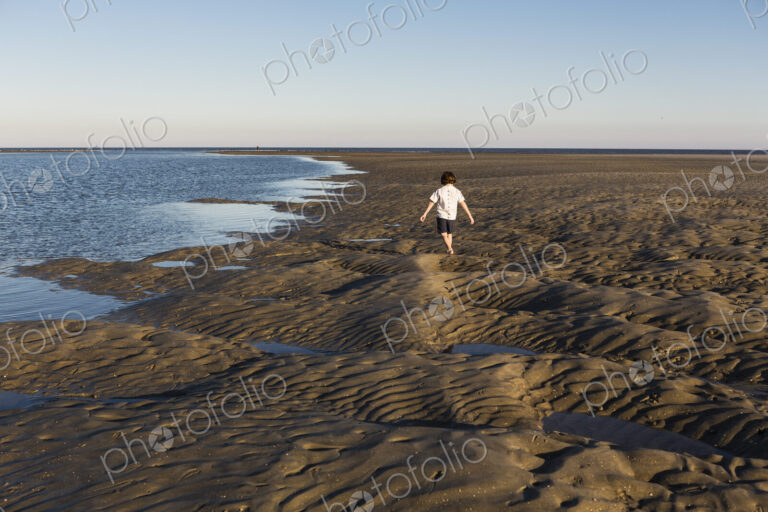 A six year old boy investigating sandy landscape