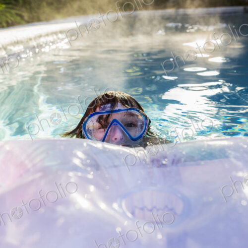 A six year old boy playing in a heated pool A six year old boy playing in a heated pool