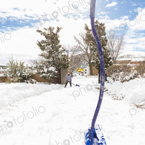 A six year old boy shoveling snow in driveway A six year old boy shoveling snow in driveway