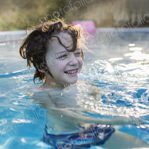 A six year old boy swimming in a warm pool. A six year old boy swimming in a warm pool.