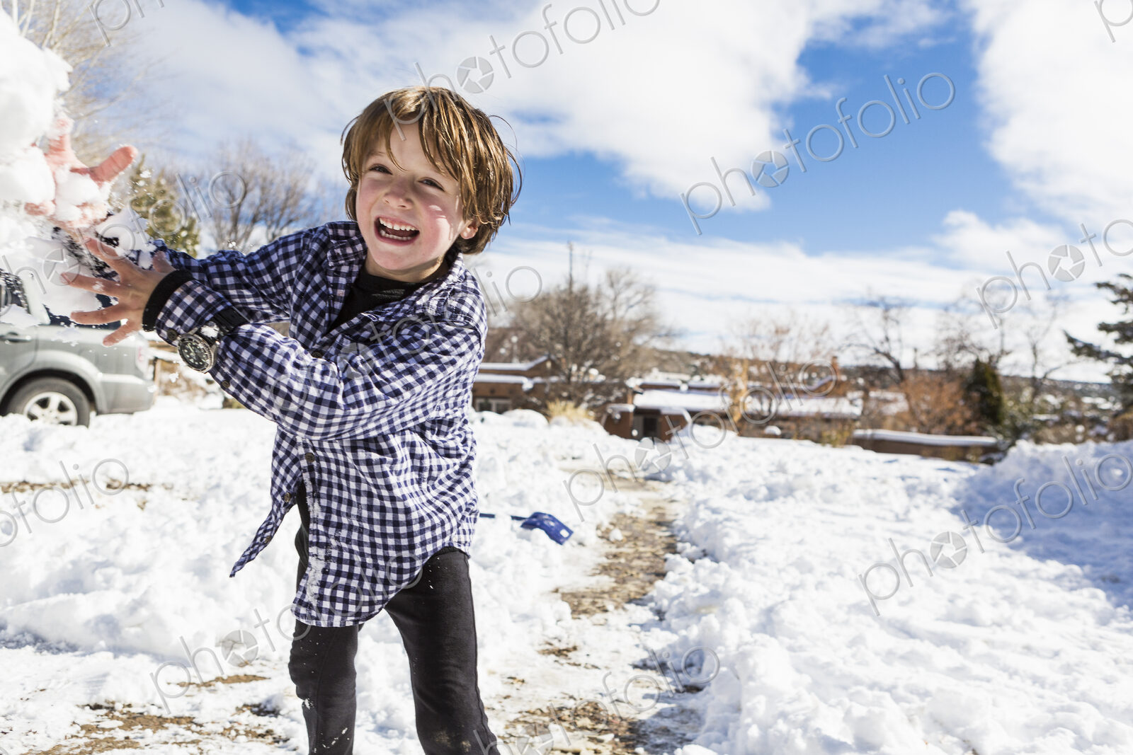 A six year old boy throwing a snowball