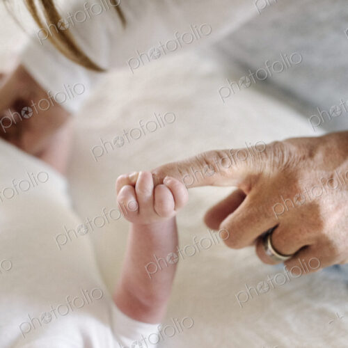 A small baby grasping his mother's finger. A small baby grasping his mother's finger.