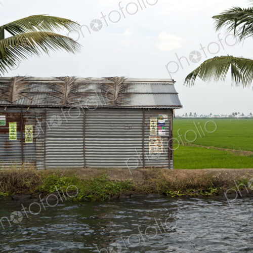 A small barn or house on the edge of a waterway or backwater,