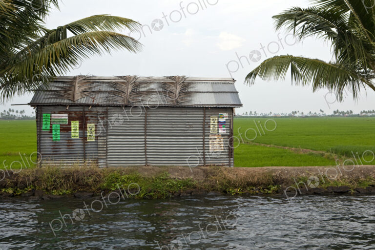 A small barn or house on the edge of a waterway or backwater,