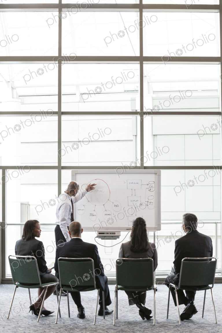 A small group of business people sitting and watching a presentation